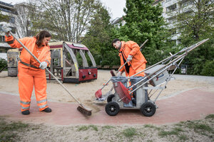 BSR-Beschäftigte beim Reinigen eines Spielplatzes